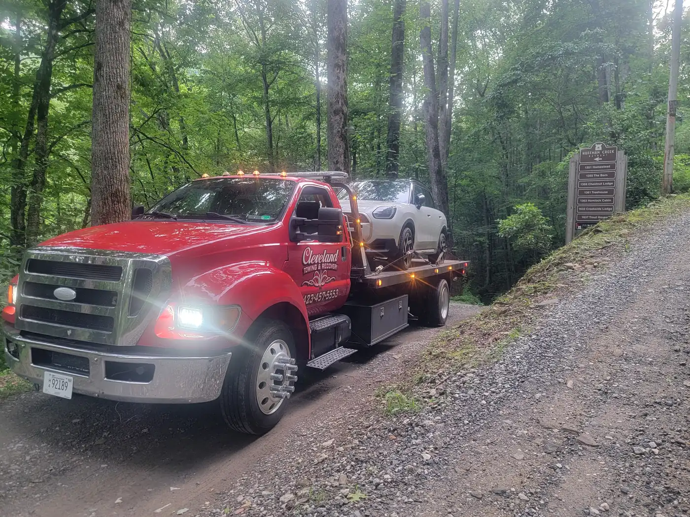 An SUV on the deck on a gravel back road, work lights on